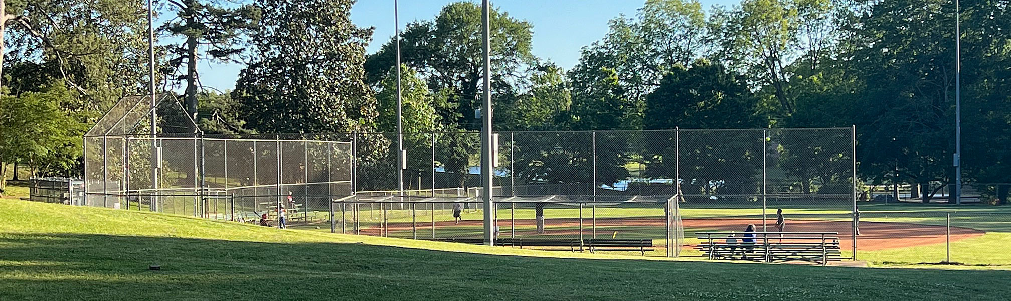 View across green lawns and East Lake Park baseball field to the lakes at the East Lake Golf Club.