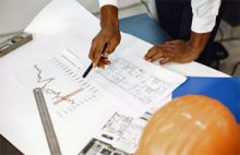 Paperwork on desk. Man's hands gesturing to an item.